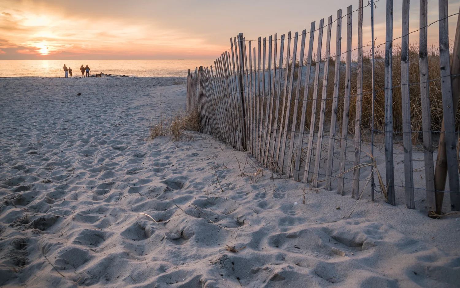 Sunset over the beach at Cape May Point with dune fencing