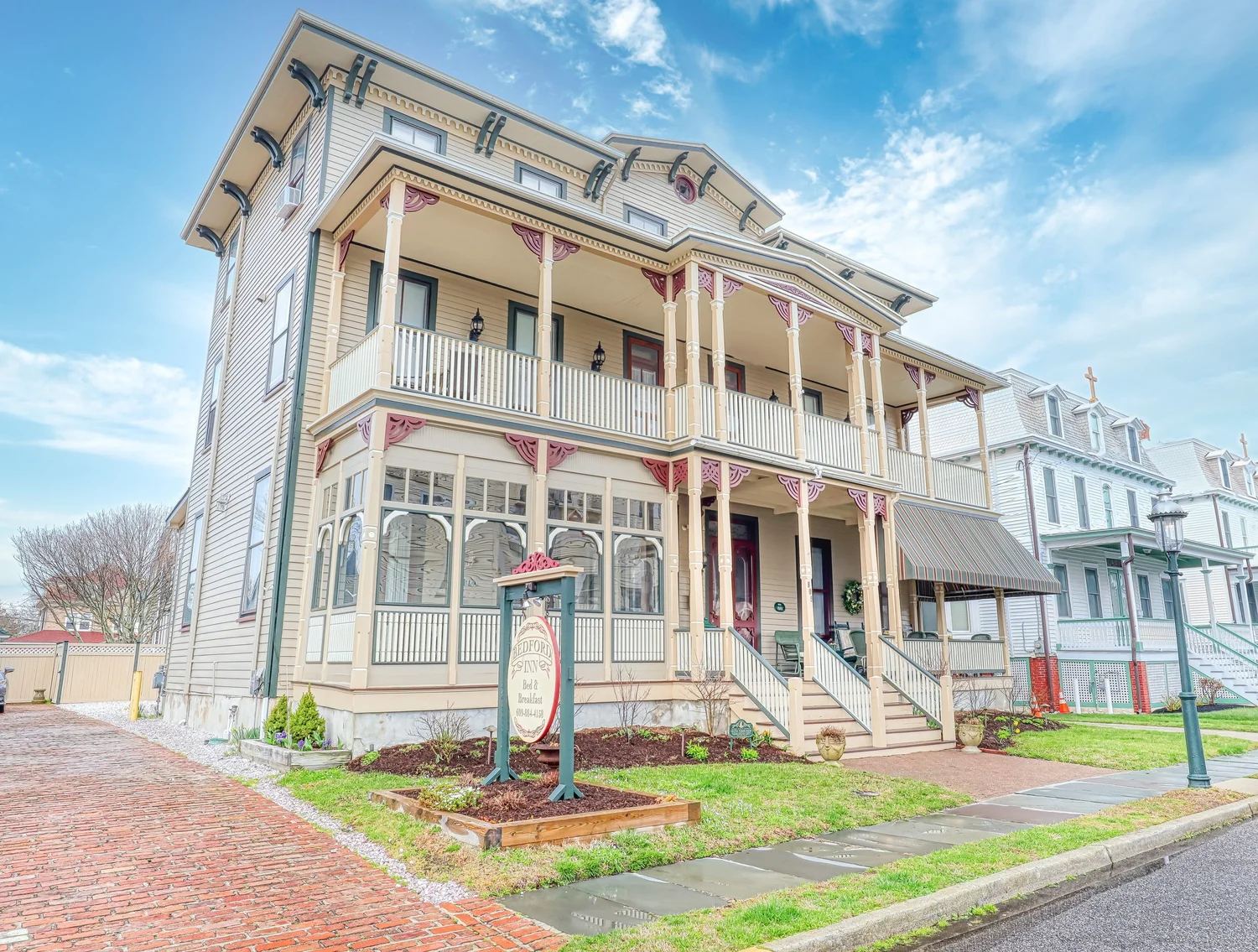 Bedford Inn, a three-story cream Victorian house with its bed and breakfast sign in Cape May
