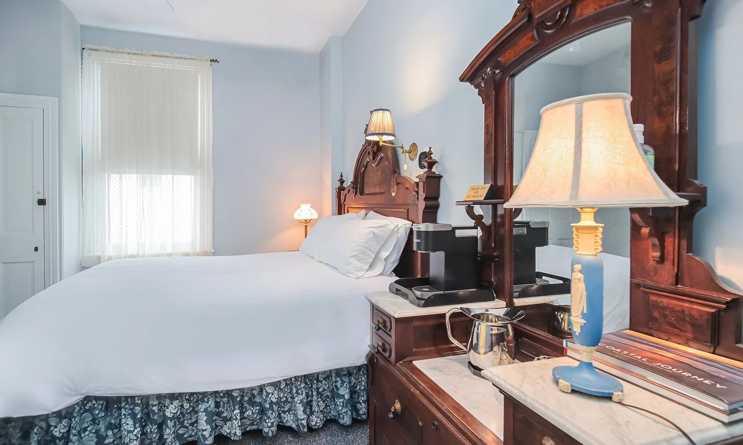 Edith's Room with pale blue walls and a carved wood bed